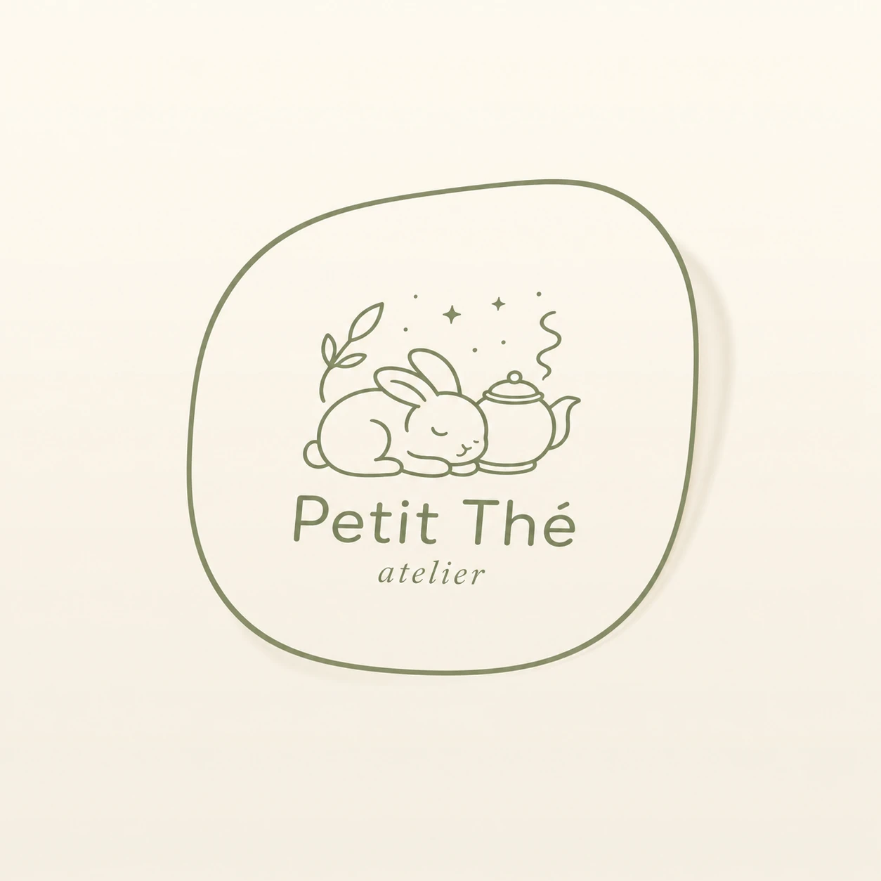 A minimalist sage-green line-art logo featuring a sleeping rabbit beside a teapot, enclosed in an organic rounded frame on a soft cream background.