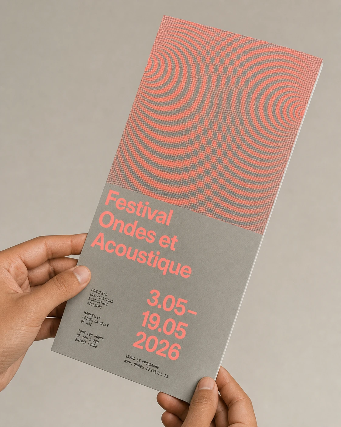 A hand holds a tall printed festival flyer featuring a coral interference-wave pattern over a warm gray field with bold sans-serif typography.