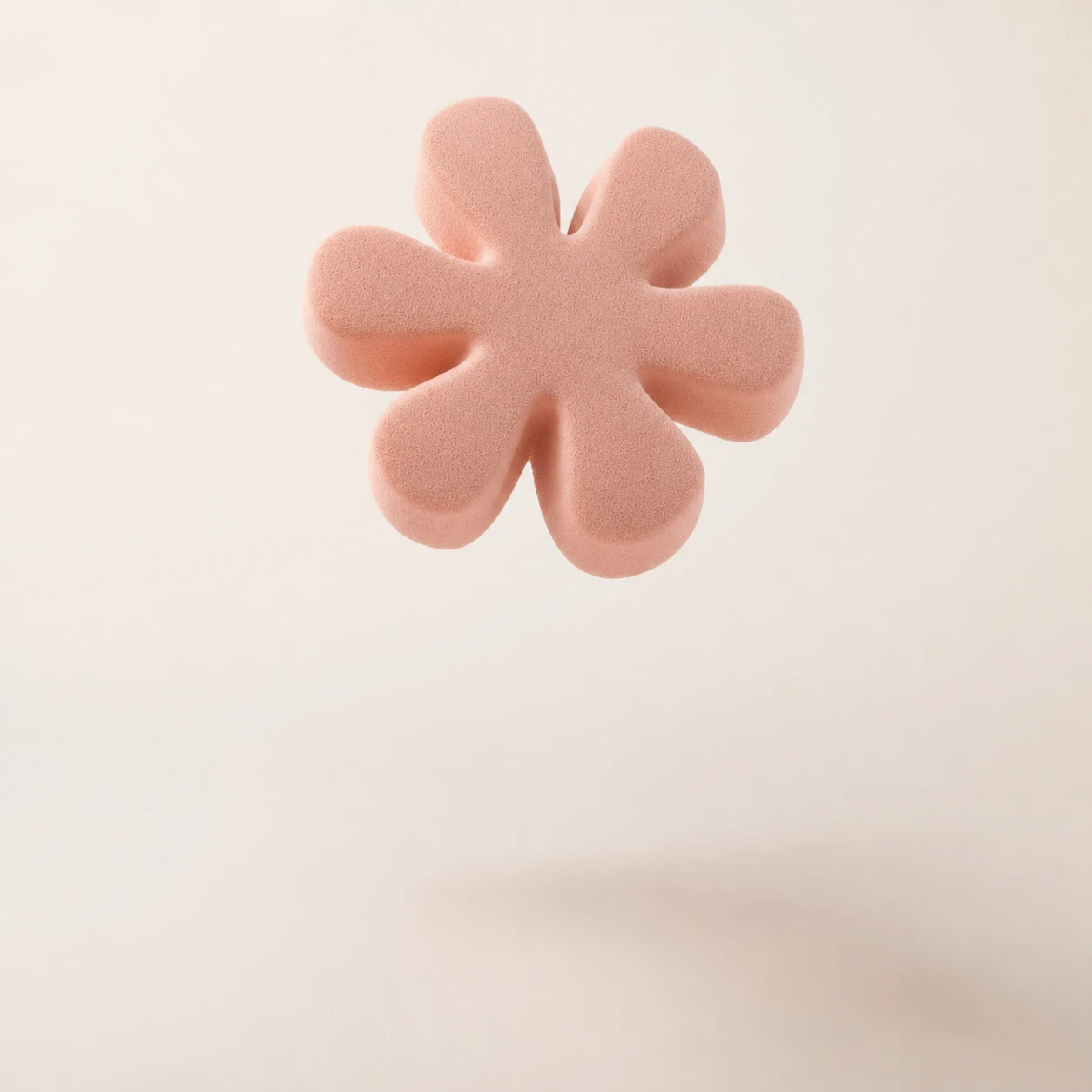 A soft pink foam flower shape floating mid-air above its blurred shadow on a neutral cream backdrop.