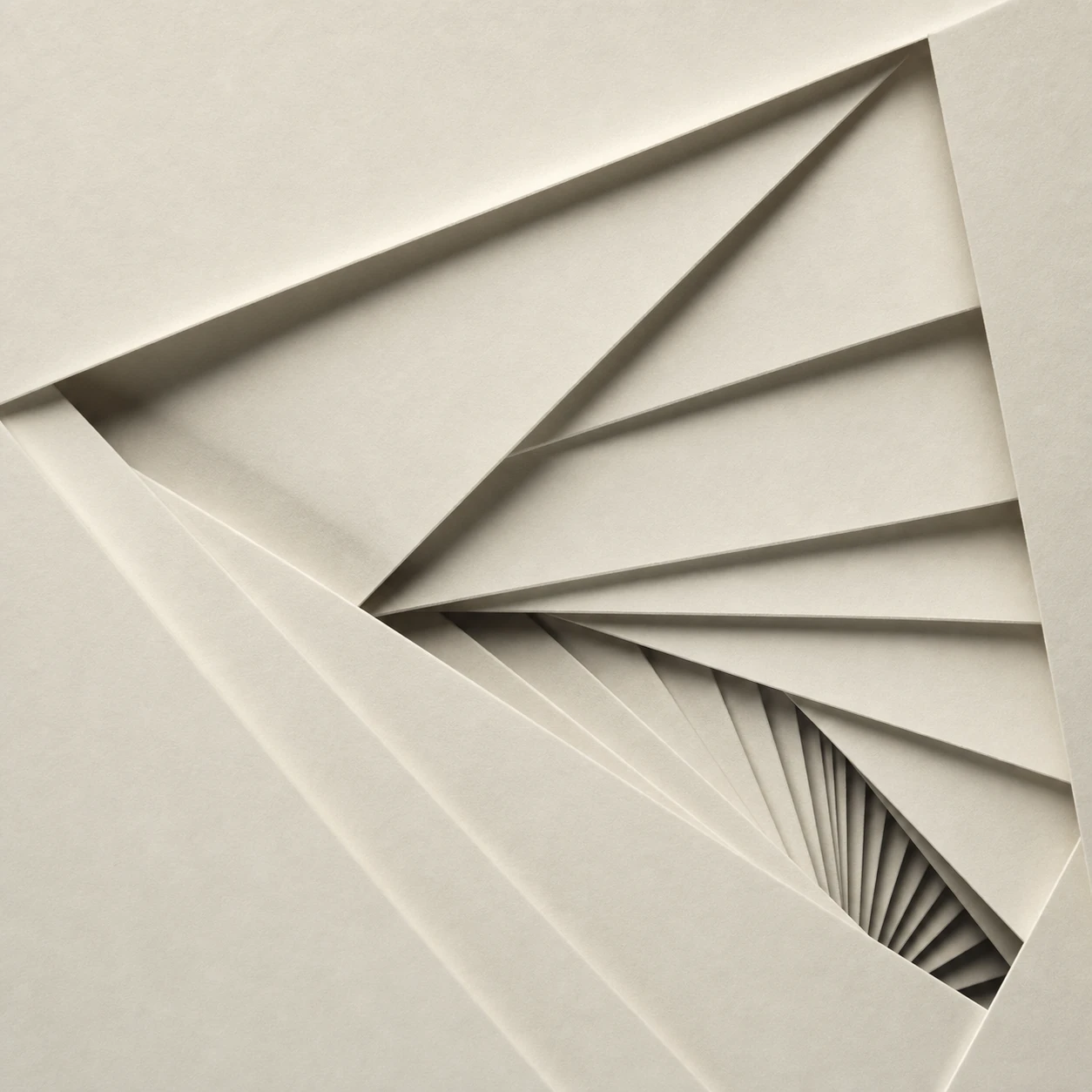 An abstract macro photograph of folded cream paper arranged into a spiraling fan of sharp angular planes converging toward a dark vortex.