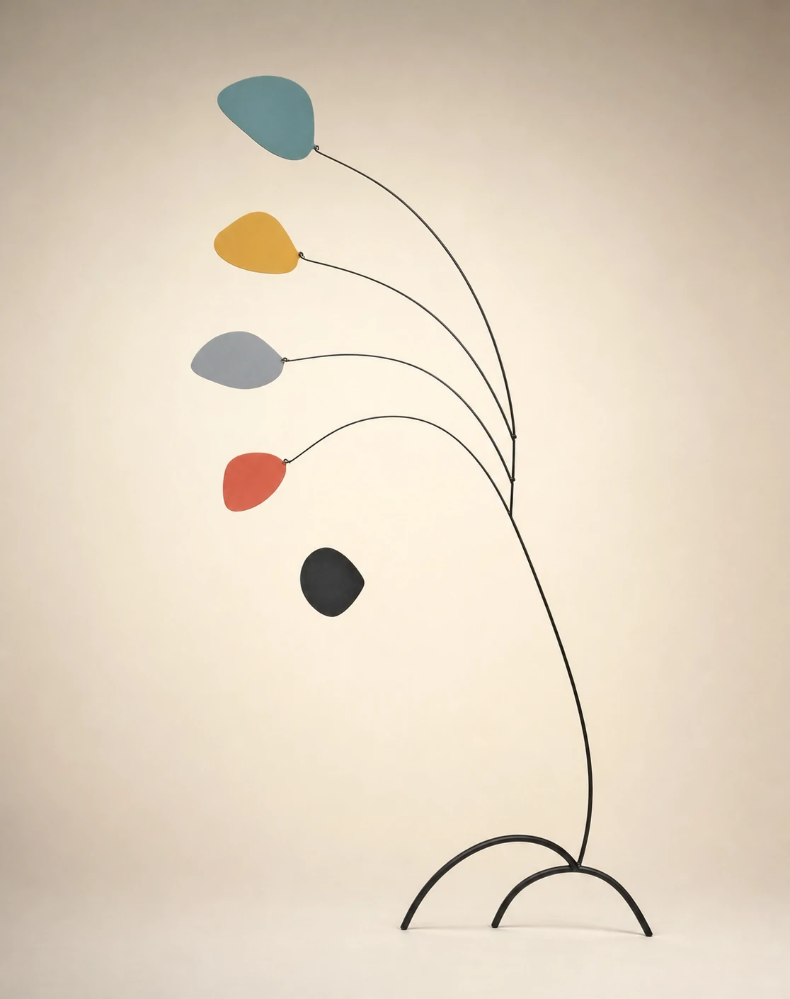 A standing kinetic mobile sculpture with colorful organic petal shapes balanced on slender black wire arms against a soft neutral backdrop.