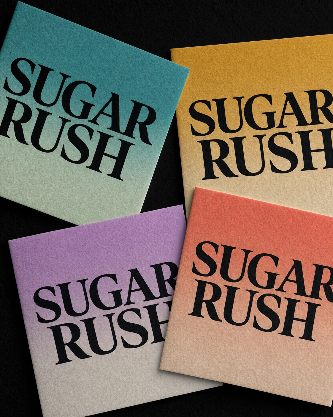 A flat-lay arrangement of four square print cards, each featuring bold black serif lettering over a gradient-colored textured paper.