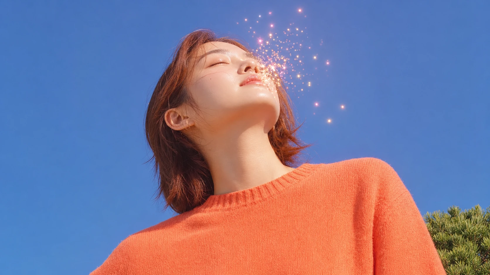 A serene young woman with eyes closed, face tilted skyward, bathed in warm sunlight against a clear blue sky with sparkling golden particles around her face.