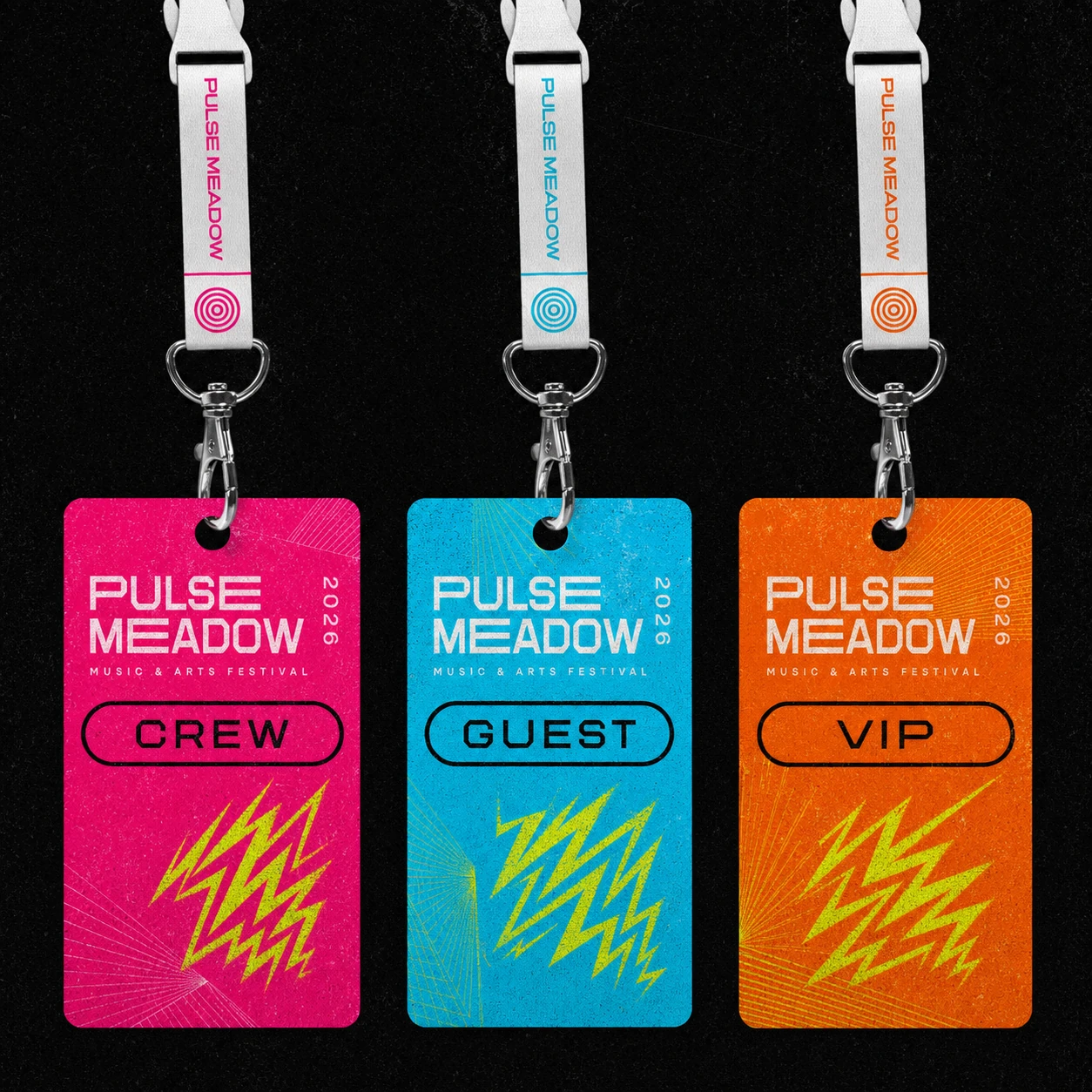 Three festival lanyard access passes in hot pink, cyan, and orange hang side by side against a dark textured background.