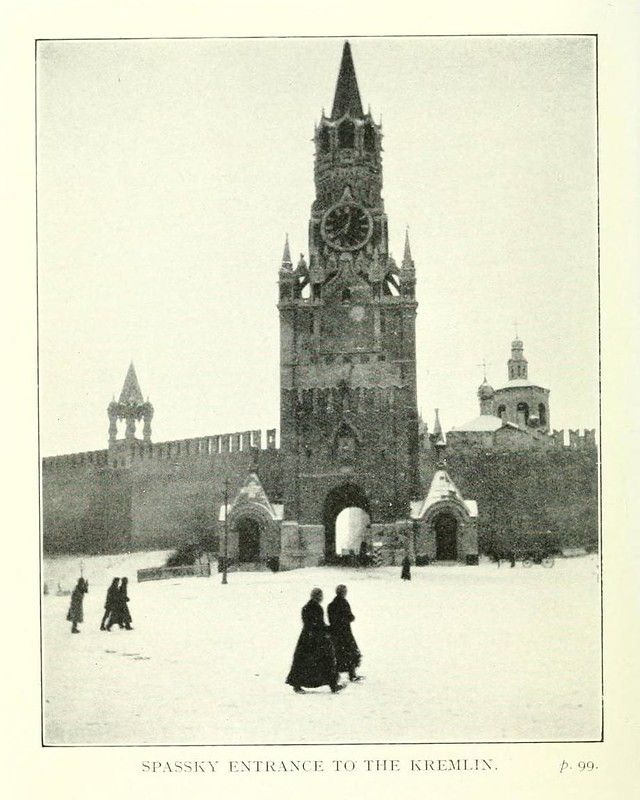Vintage black and white photograph of the Spassky Entrance to the Kremlin, featuring a tall tower, brick wall, and people walking in the snow.