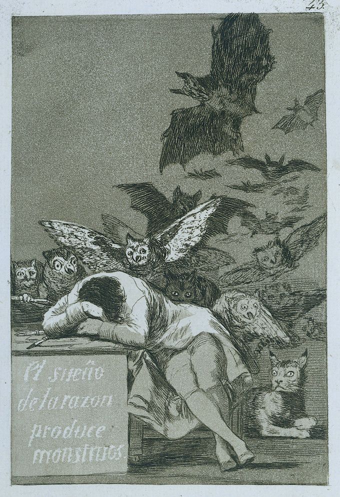 A black and white etching depicting a man asleep surrounded by owls and bats, with a cat looking on. A stone tablet reads 'El sueño de la razón produce monstruos.'