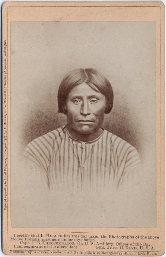 Vintage photograph of a Native American man in patterned shirt.