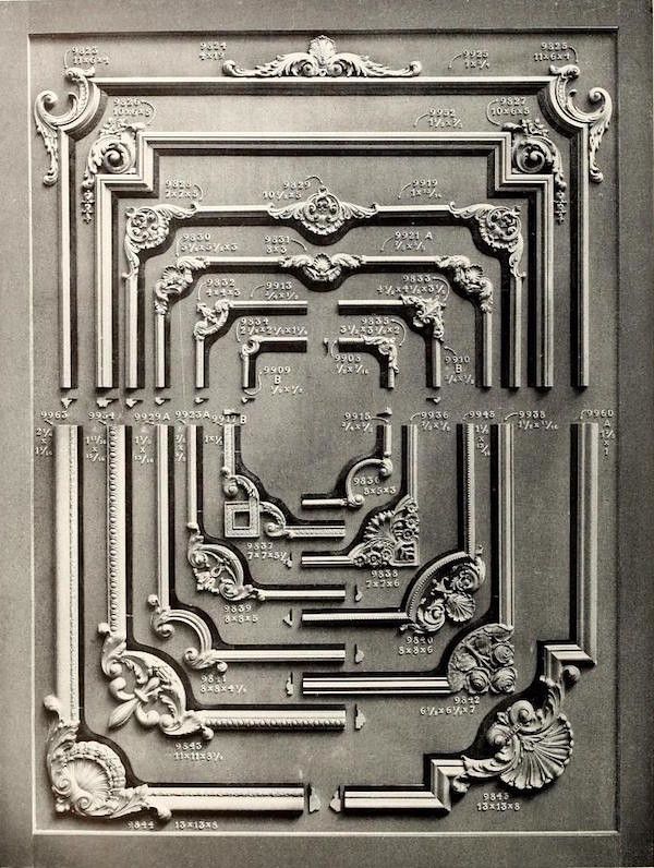 A black and white photograph of an ornate metal or cast iron design with numerous numbers and measurements inscribed alongside the design elements.