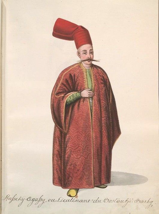 A full-length portrait of a man in historical attire, wearing a red hat and robe, with a white mustache and holding a sword.