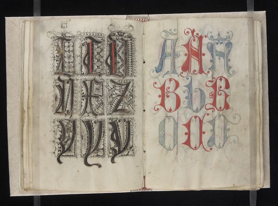 An open page from a medieval manuscript with elaborate, decorative letters in red, blue, and black.