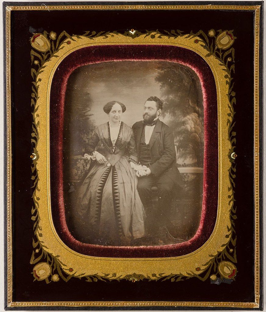 A daguerreotype portrait of a couple in ornate frame.