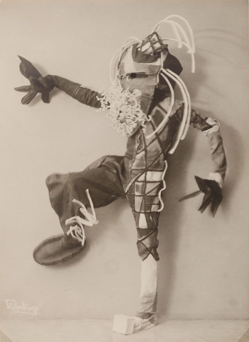 A vintage black and white photograph of a person wearing a highly unusual and avant-garde costume.
