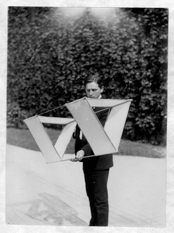 Black and white photograph of a man holding a geometric structure.