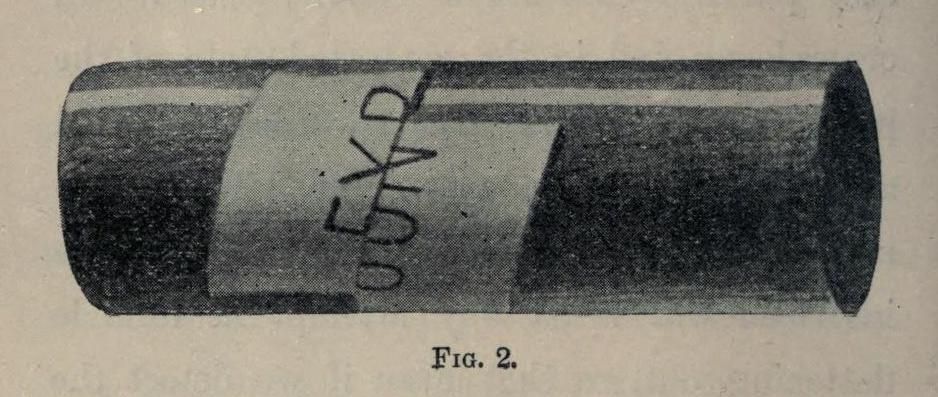 A grainy black and white image of a cylindrical object with a label reading "0.5 KD".