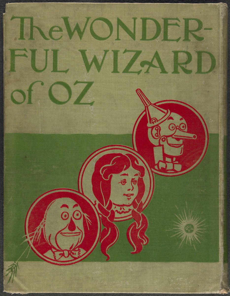 Book cover for 'The Wonderful Wizard of Oz' with green background and red illustrations of the Wizard, Dorothy, and the Tin Man.