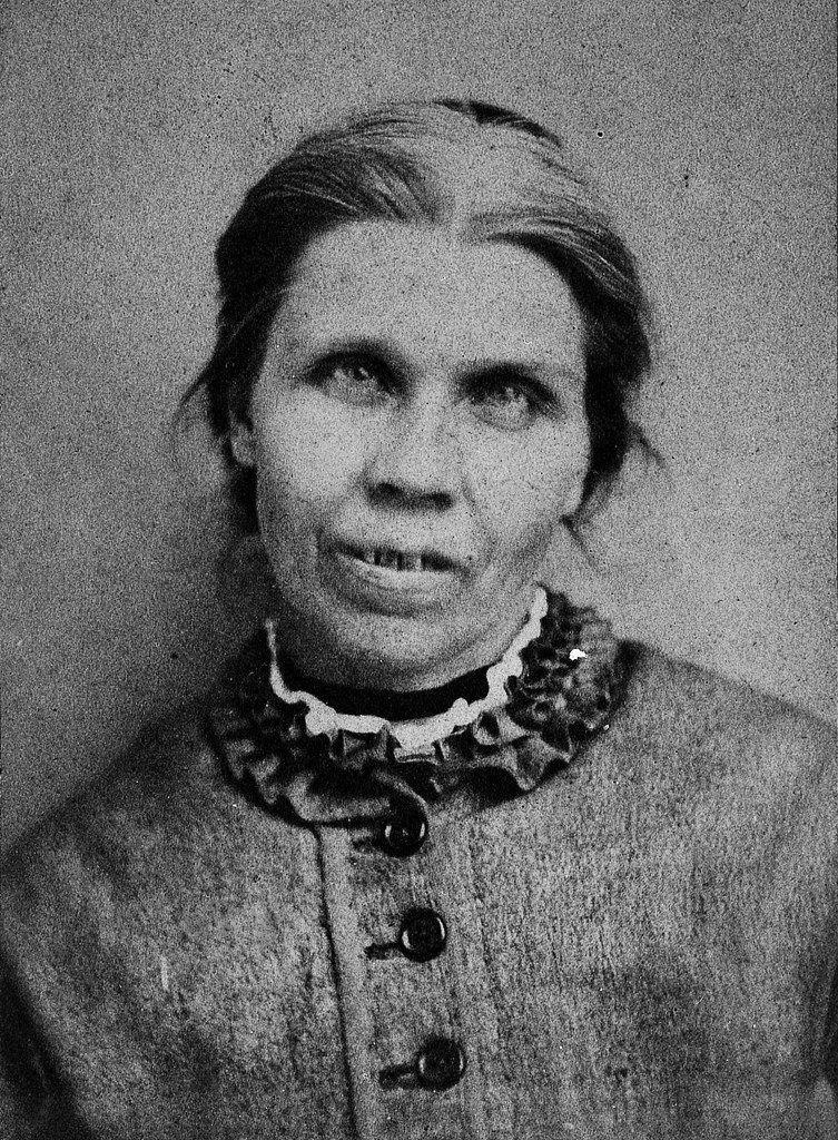 Vintage black and white portrait of a woman with a serious expression.