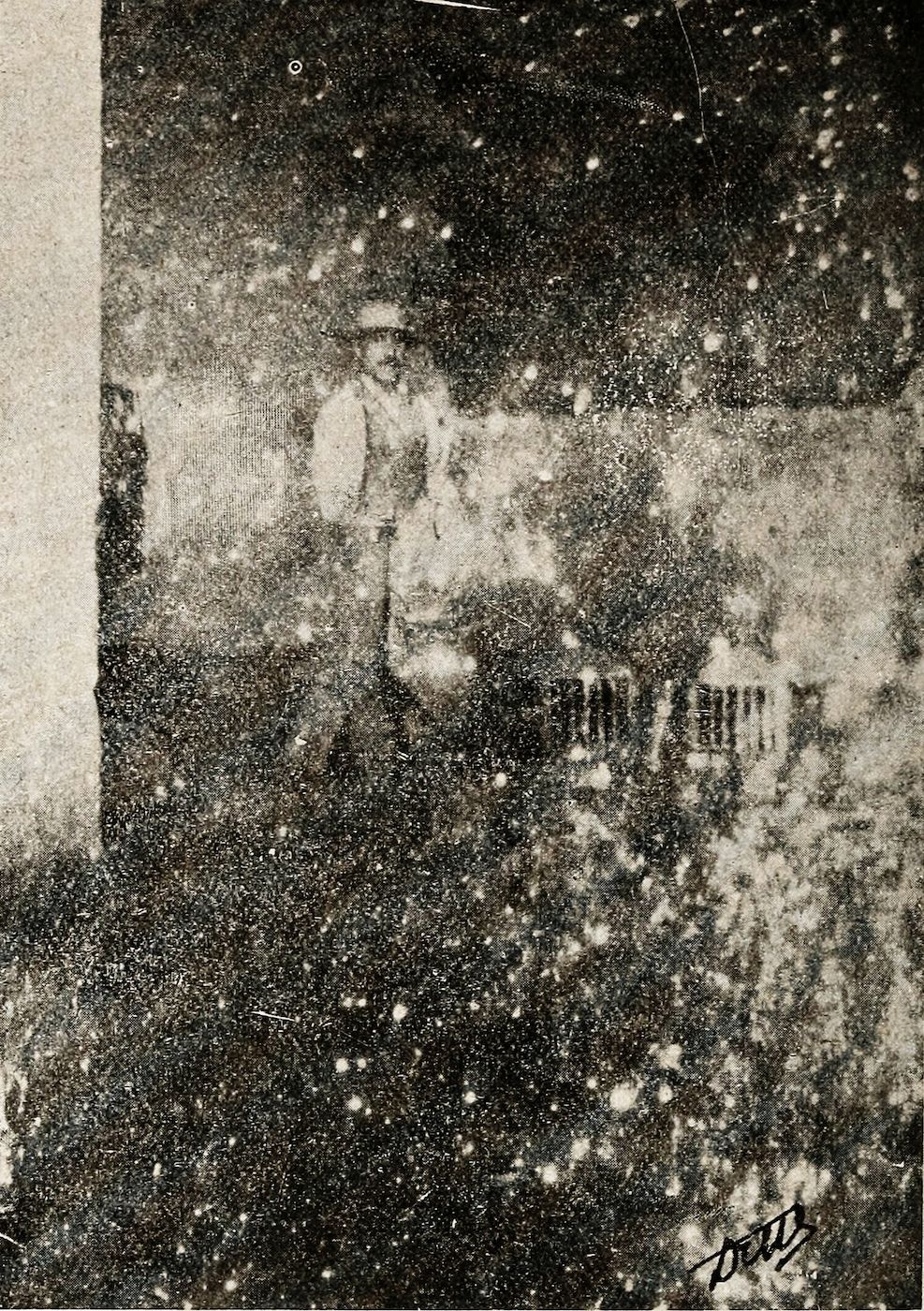 A grainy black and white photograph of a street scene with a building and falling snow, heavily distressed with scratches and blemishes.
