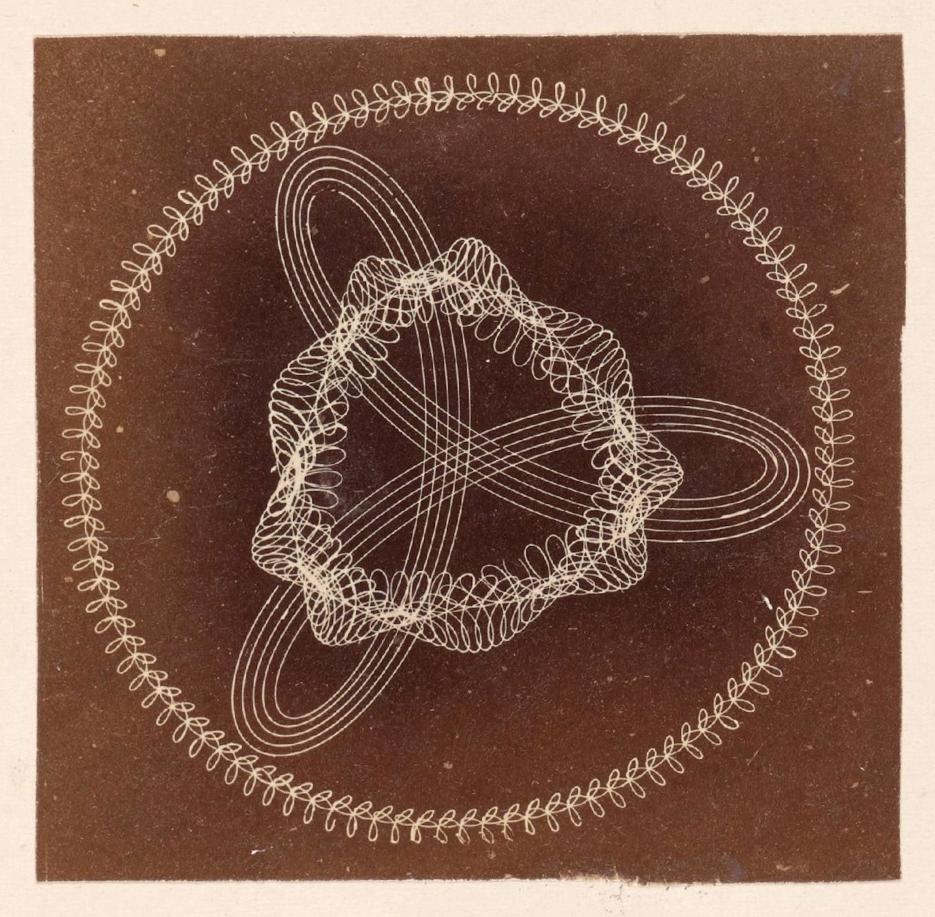 A sepia-toned photograph of a complex geometric pattern, resembling a Lissajous curve, with swirling lines forming a symmetrical, floral design.