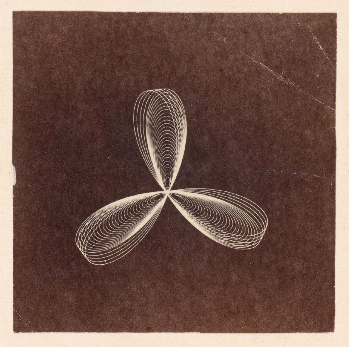 A sepia-toned photograph of a complex geometric pattern resembling a three-leaf clover or stylized flower, created by concentric elliptical curves.