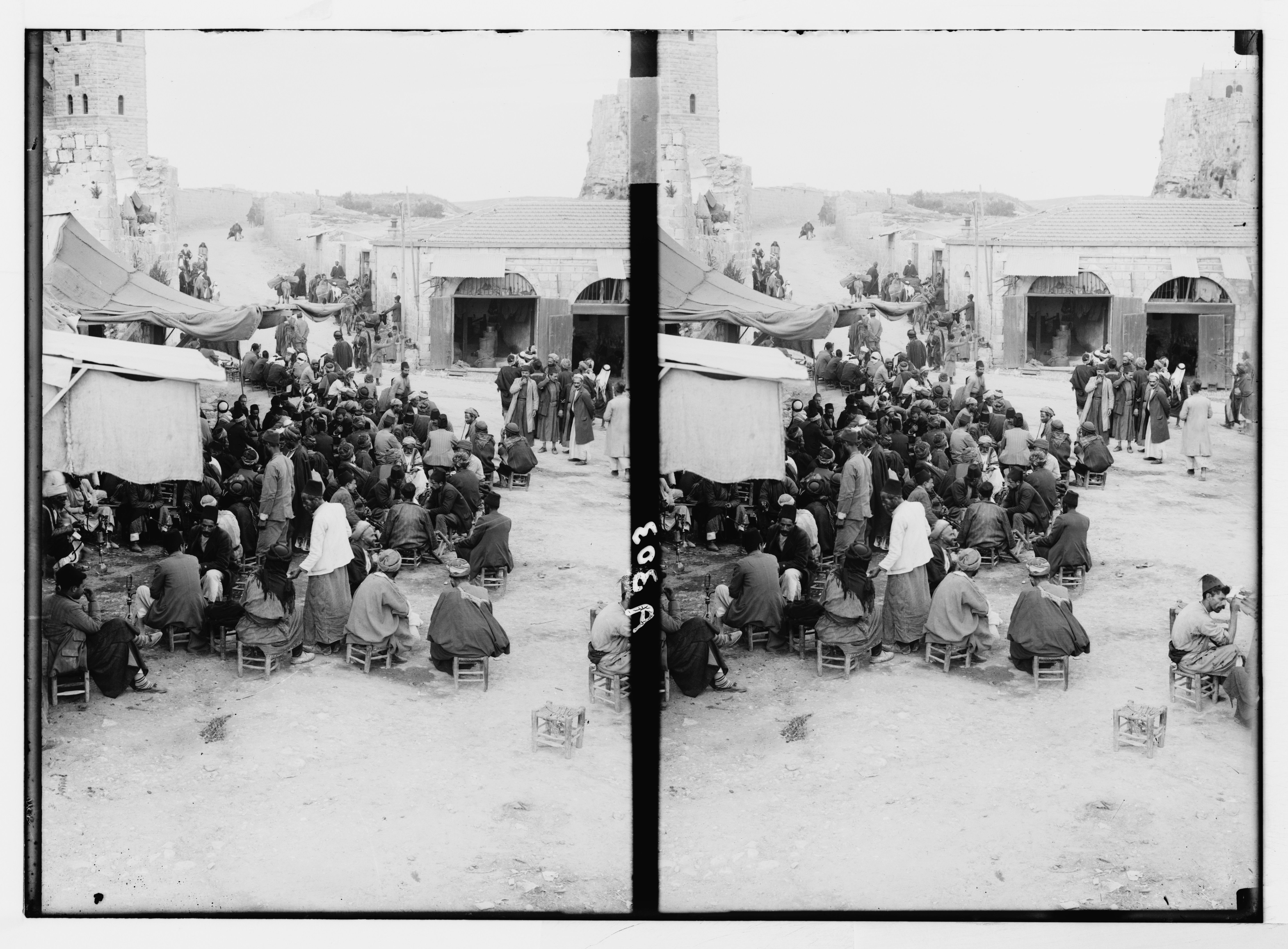 Stereoscopic photograph of a crowded marketplace or gathering in a historical setting, with people dressed in traditional clothing and tents set up around a stone courtyard.