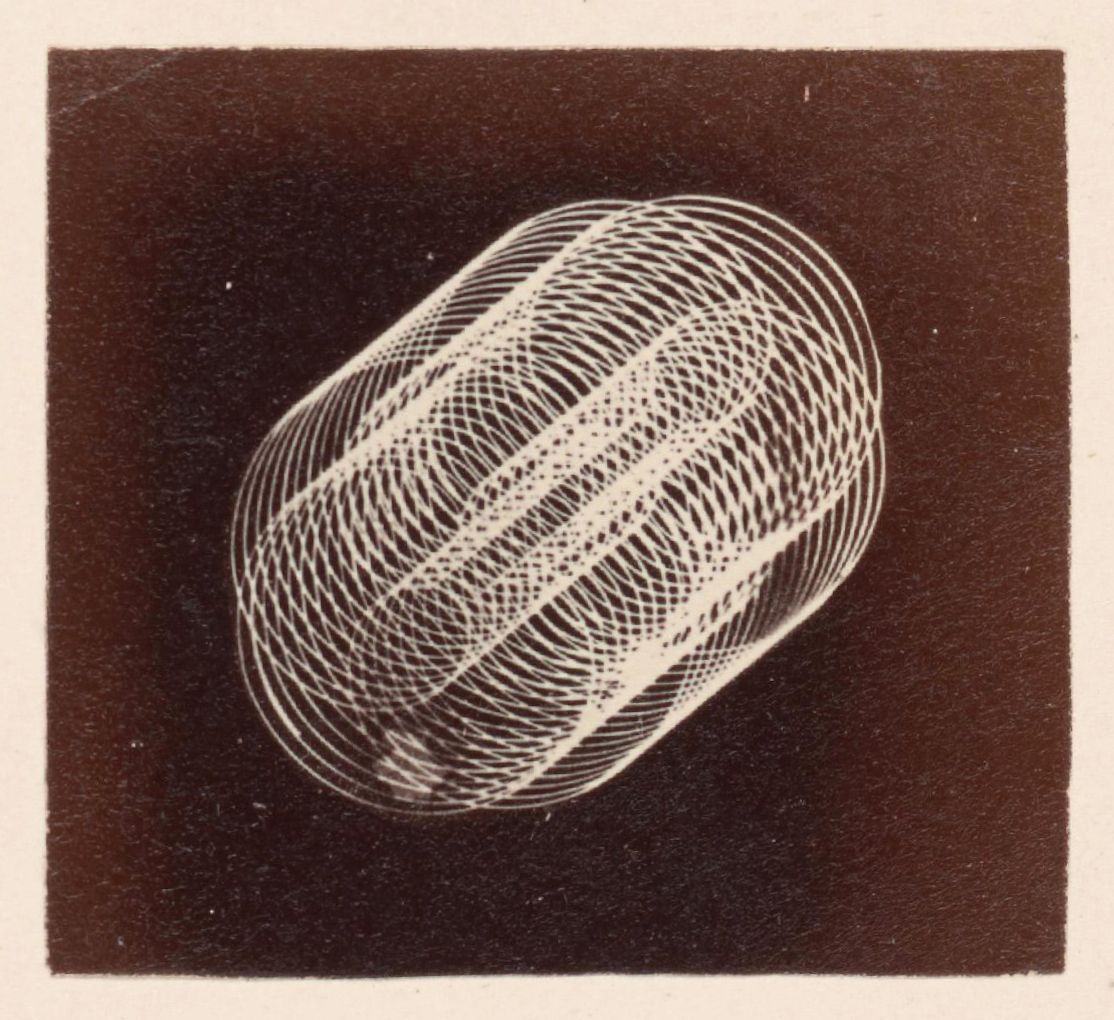 A vintage photograph of a complex, abstract pattern resembling a distorted sphere constructed from a multitude of thin, curving lines against a dark background.
