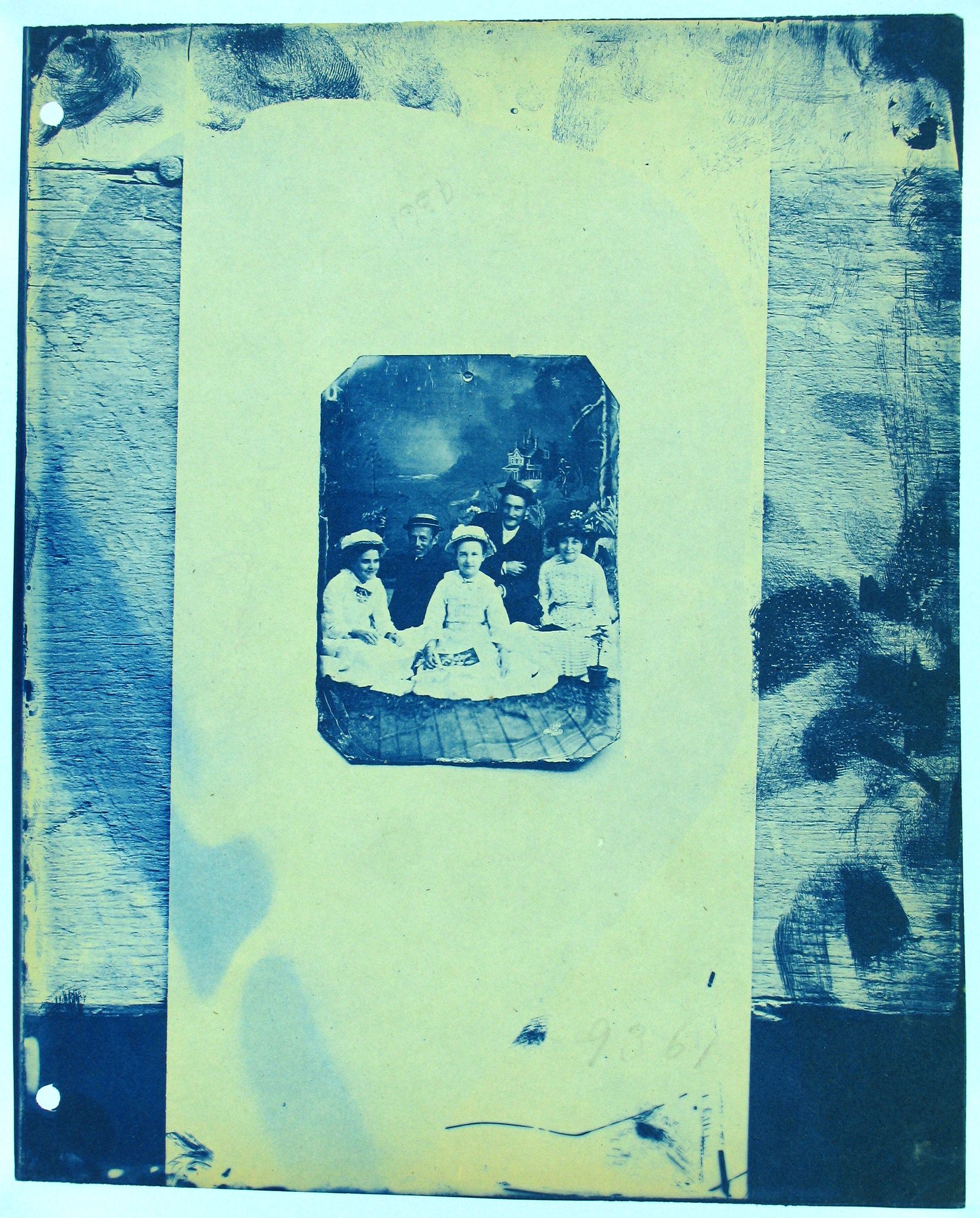 A vintage photograph of a family, encased within a protective sleeve and album page.