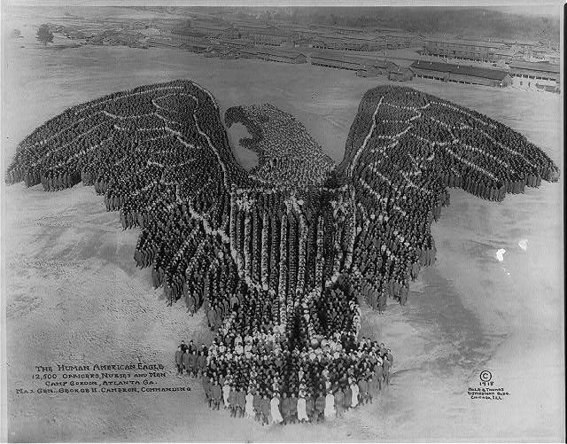 A black and white photograph of a large group of people forming the shape of an American eagle at Camp Gordon, Atlanta, Georgia in 1918.