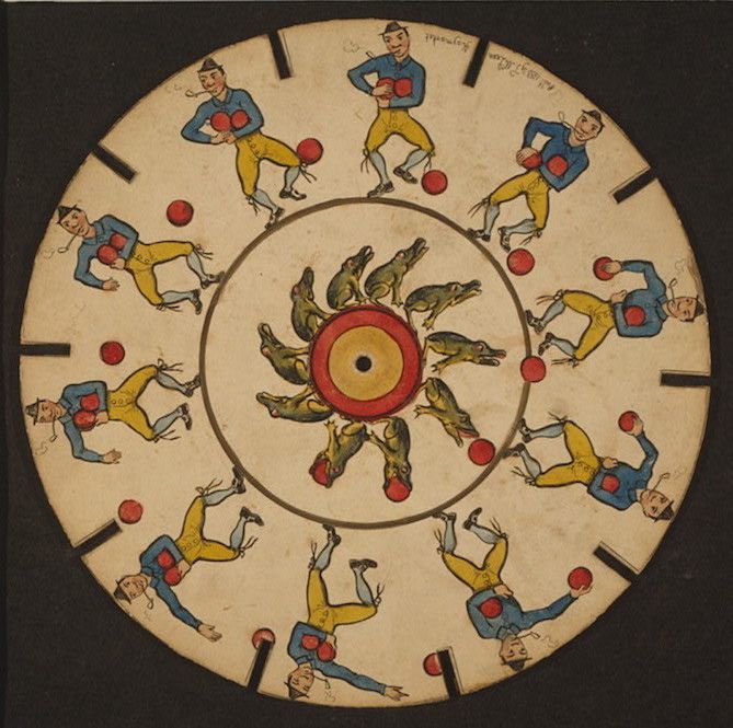 A vintage zoetrope disc with illustrations of a man kicking a ball and frogs in the center.