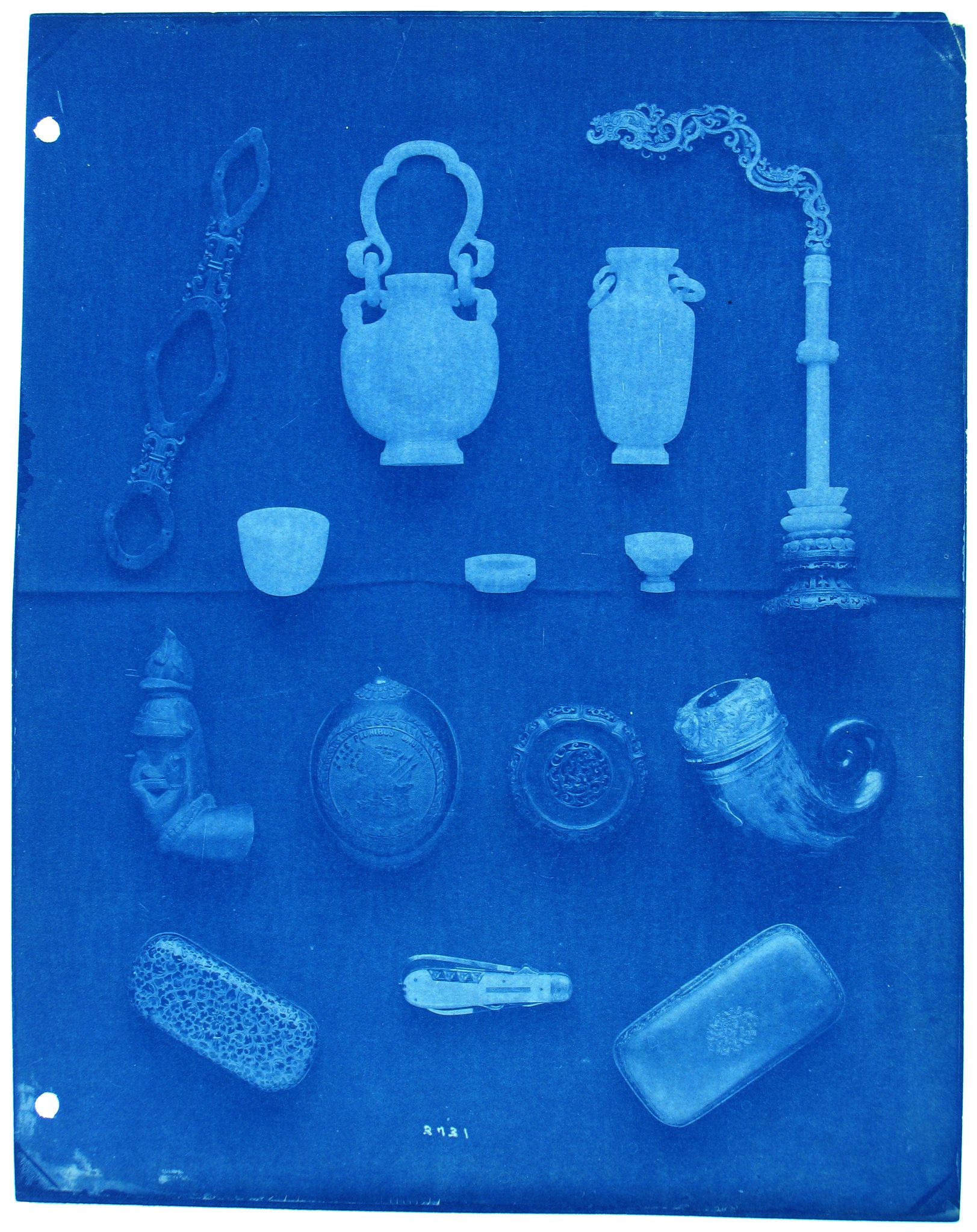 A cyanotype photograph of a collection of ancient artifacts, including pottery vessels, small containers, and other objects, arranged in rows on a flat surface.