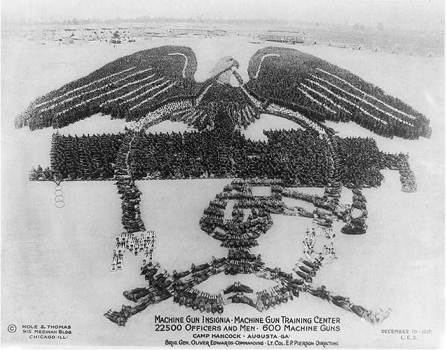 A black and white photograph of a large group of soldiers arranged to form the shape of an eagle.