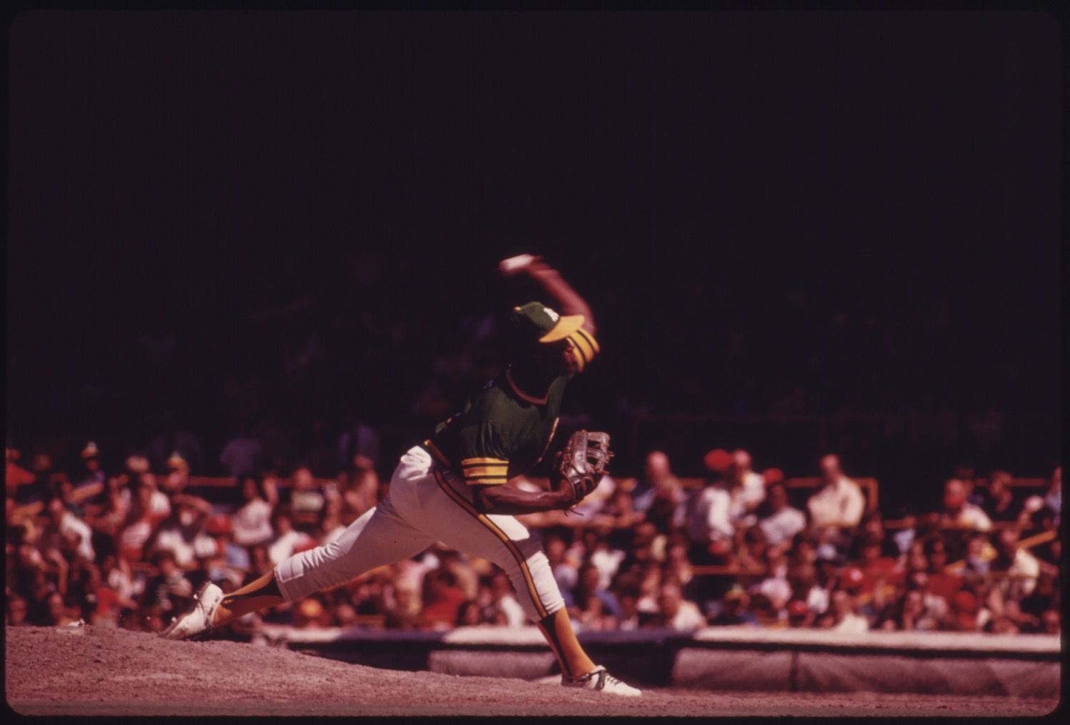 A baseball pitcher in mid-throw, with a crowd in the background.