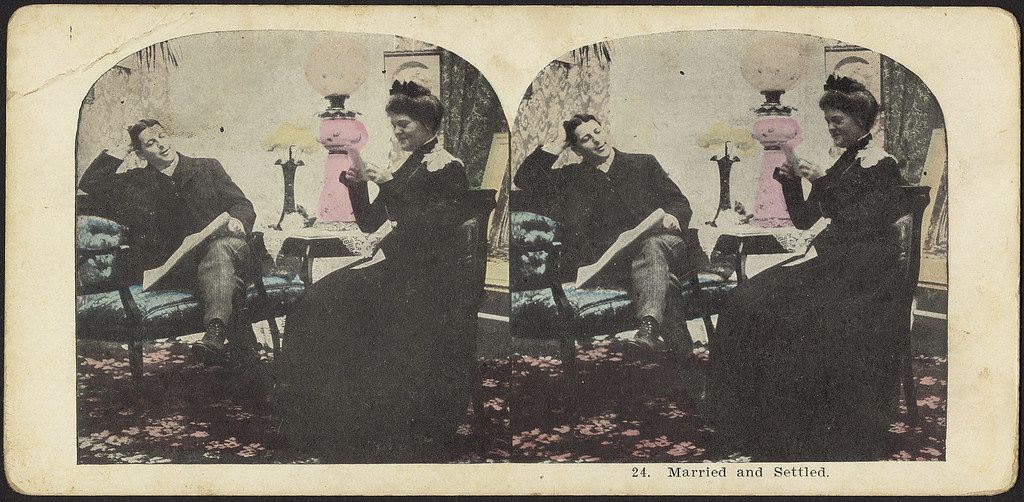 Stereoscopic card titled "Married and Settled" depicting a man and a woman seated in a comfortably furnished room.