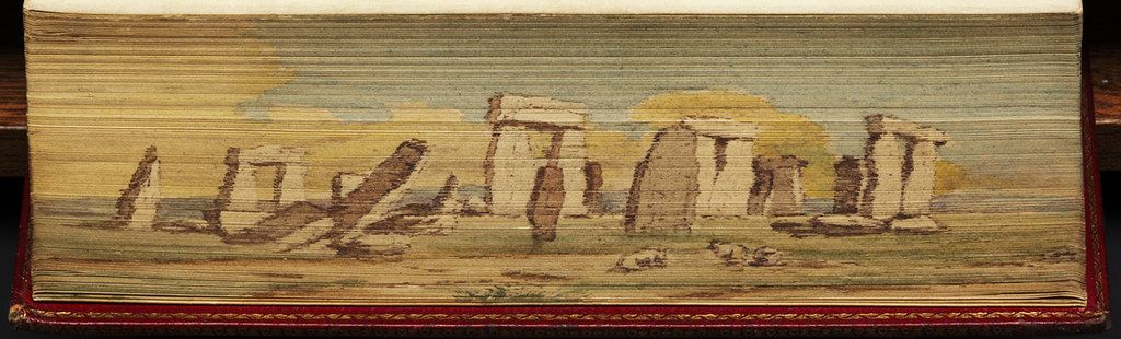 Watercolor painting of Stonehenge, a prehistoric monument in Wiltshire, England, framed by the edges of a book.