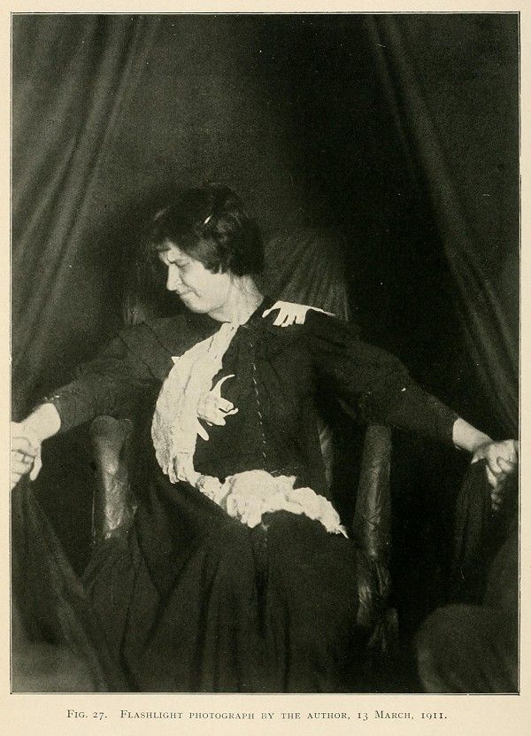 Vintage photograph of a woman in a dark dress seated in a chair, taken on March 13, 1911.
