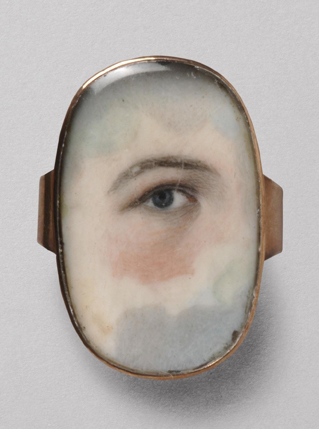 Close-up of a vintage mourning ring with a painted miniature portrait of an eye.