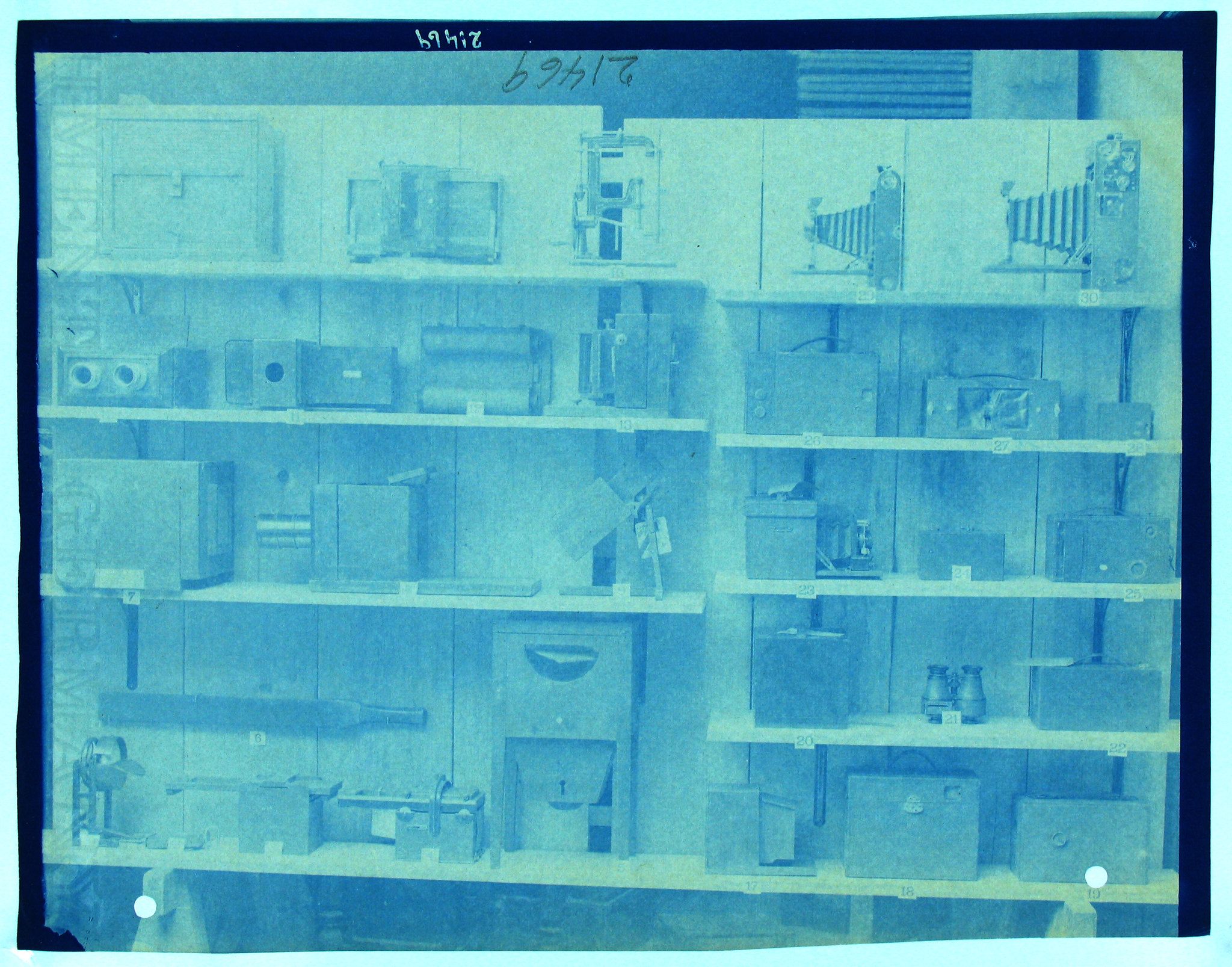 A collection of blueprints or technical drawings arranged on shelves, with a blue tint and a vintage feel.