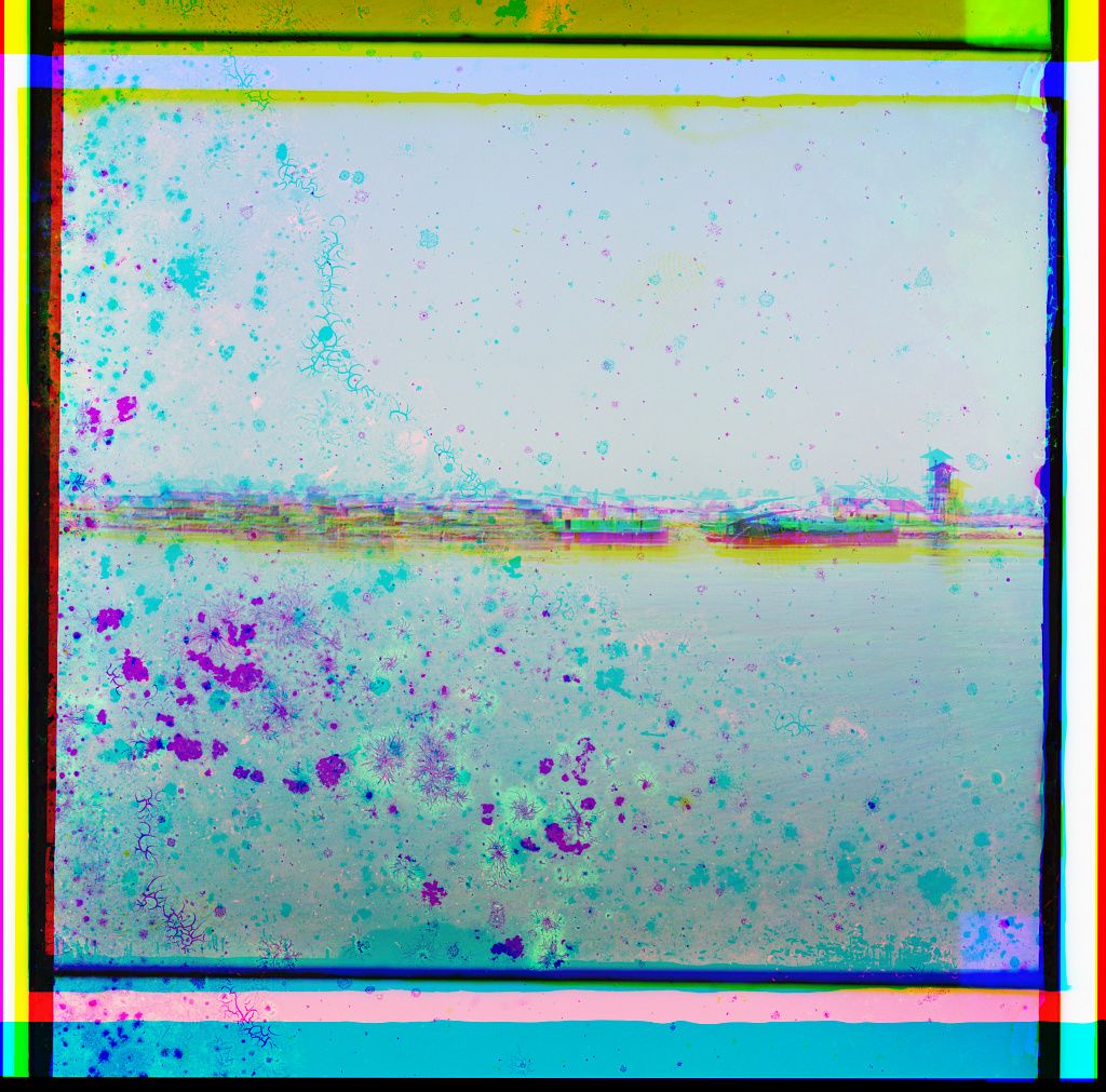 A vintage-style landscape with a body of water, land, and buildings, featuring color fringing and a speckled texture.