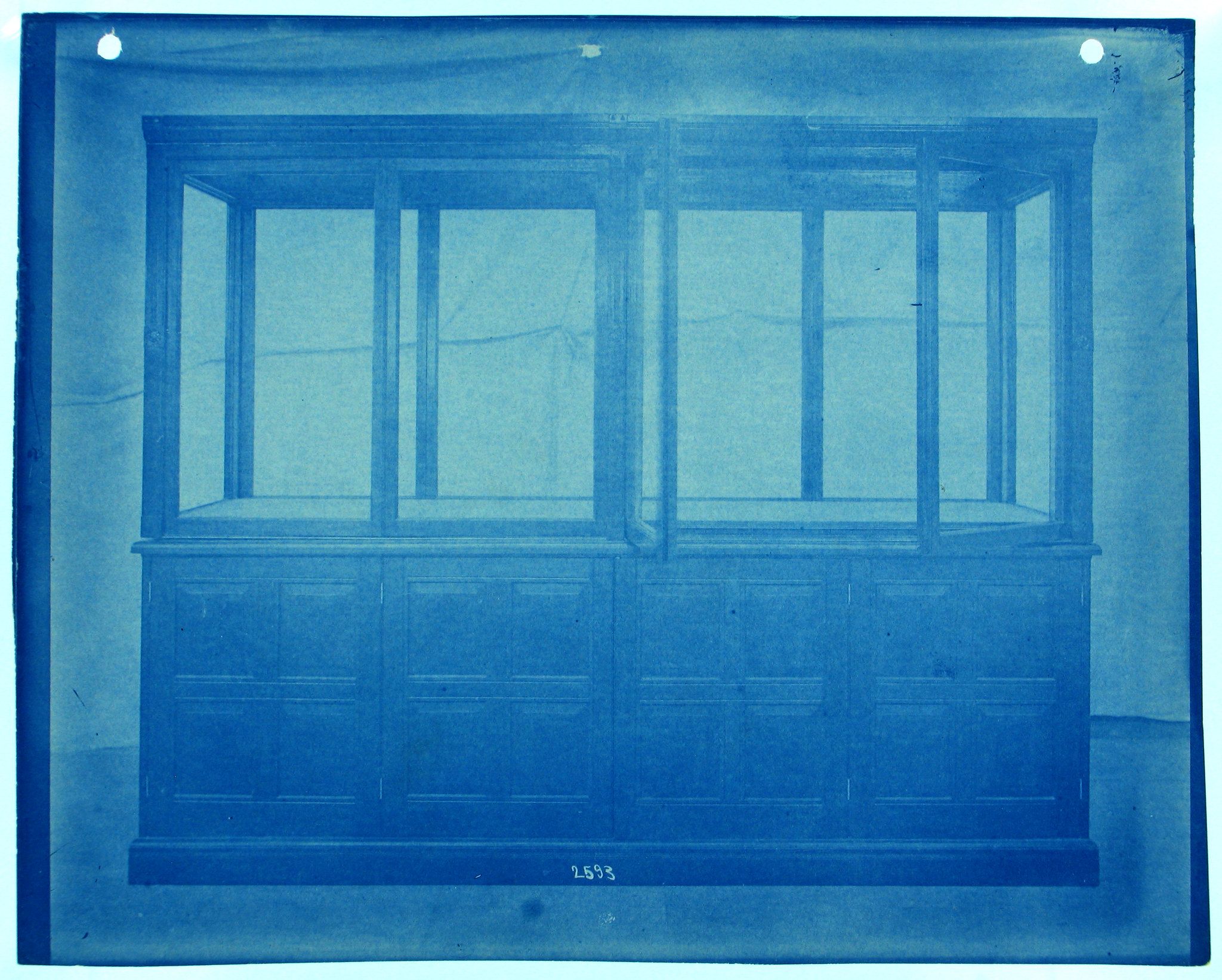 Vintage cyanotype photograph of a large, ornate cabinet with a grid-like pattern resembling a window.