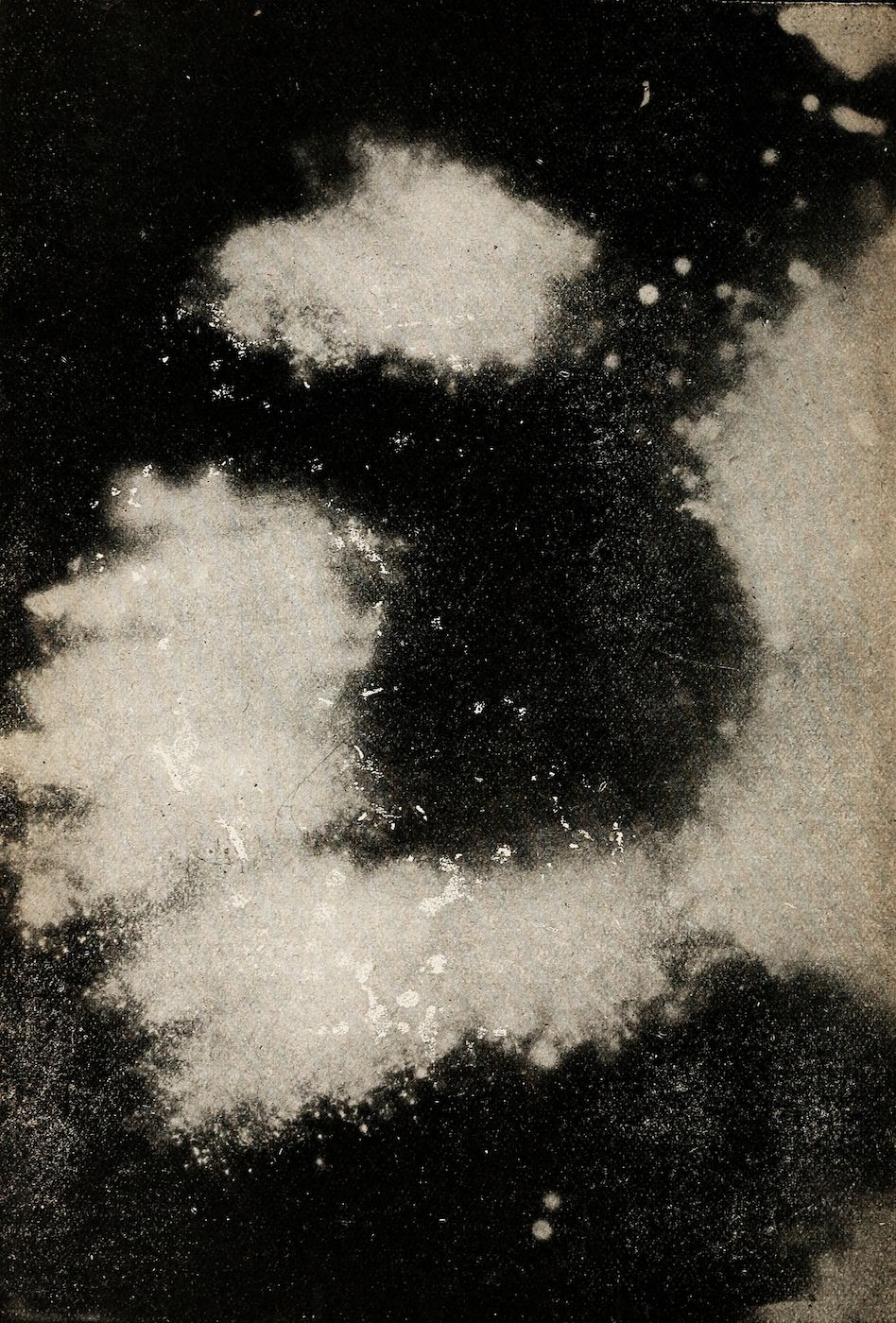 Abstract image with dark background and light cloud-like shapes forming a circular pattern.