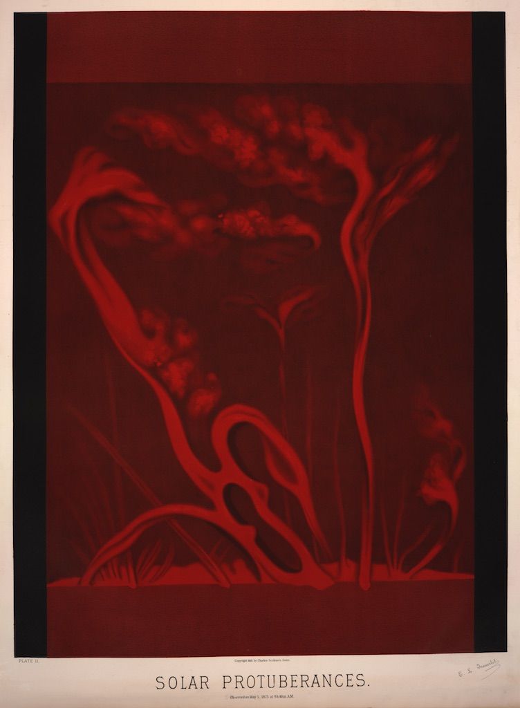 Vintage astronomical photograph of solar prominences, showing fiery, looping structures in shades of red and orange against a dark background.