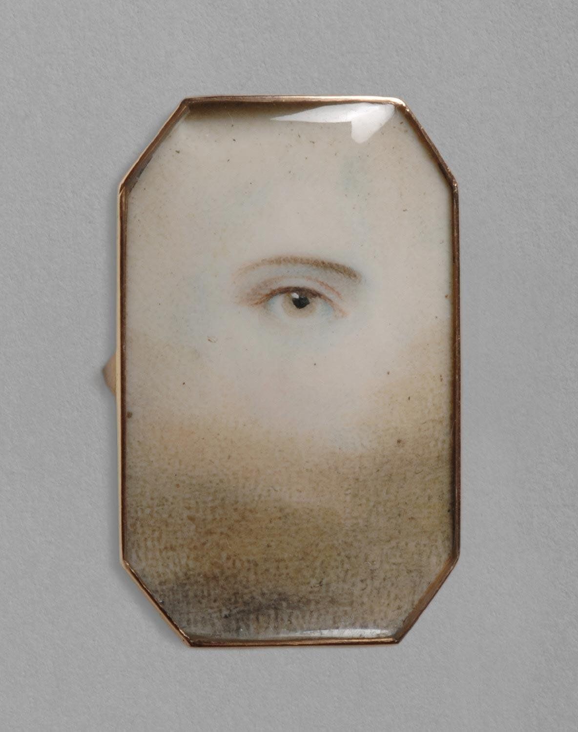 Close-up daguerreotype portrait of a person's eye and beard in an octagonal frame.