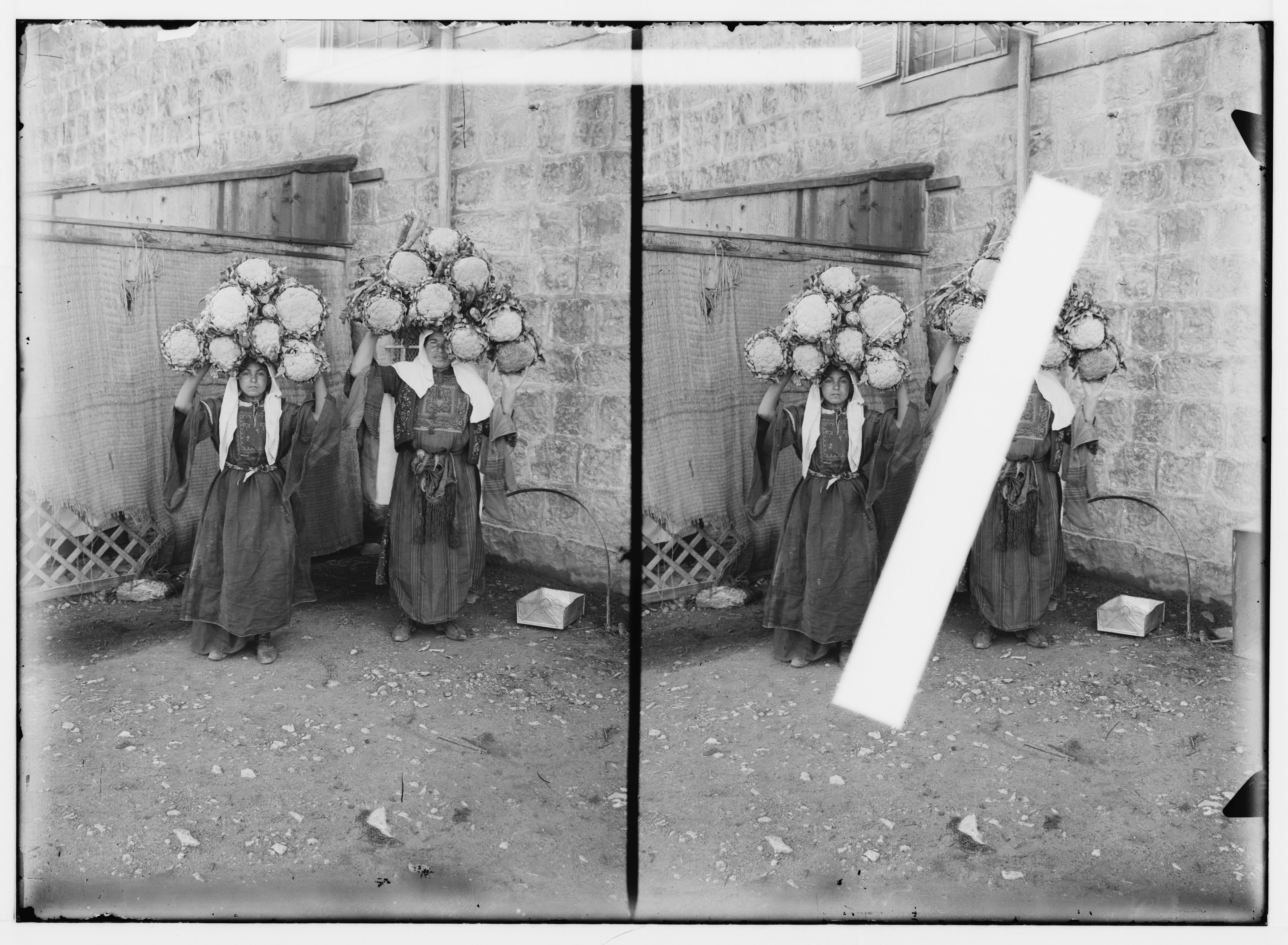 Stereoscopic photograph of two women wearing flower headwear against a textured wall.