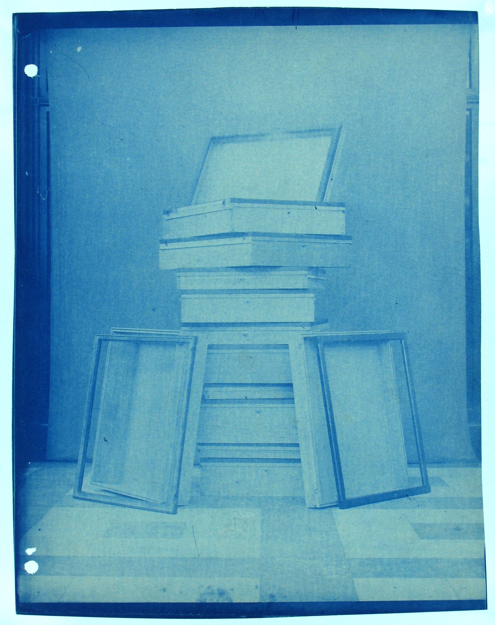 cyanotype photograph of a stack of window frames in a room