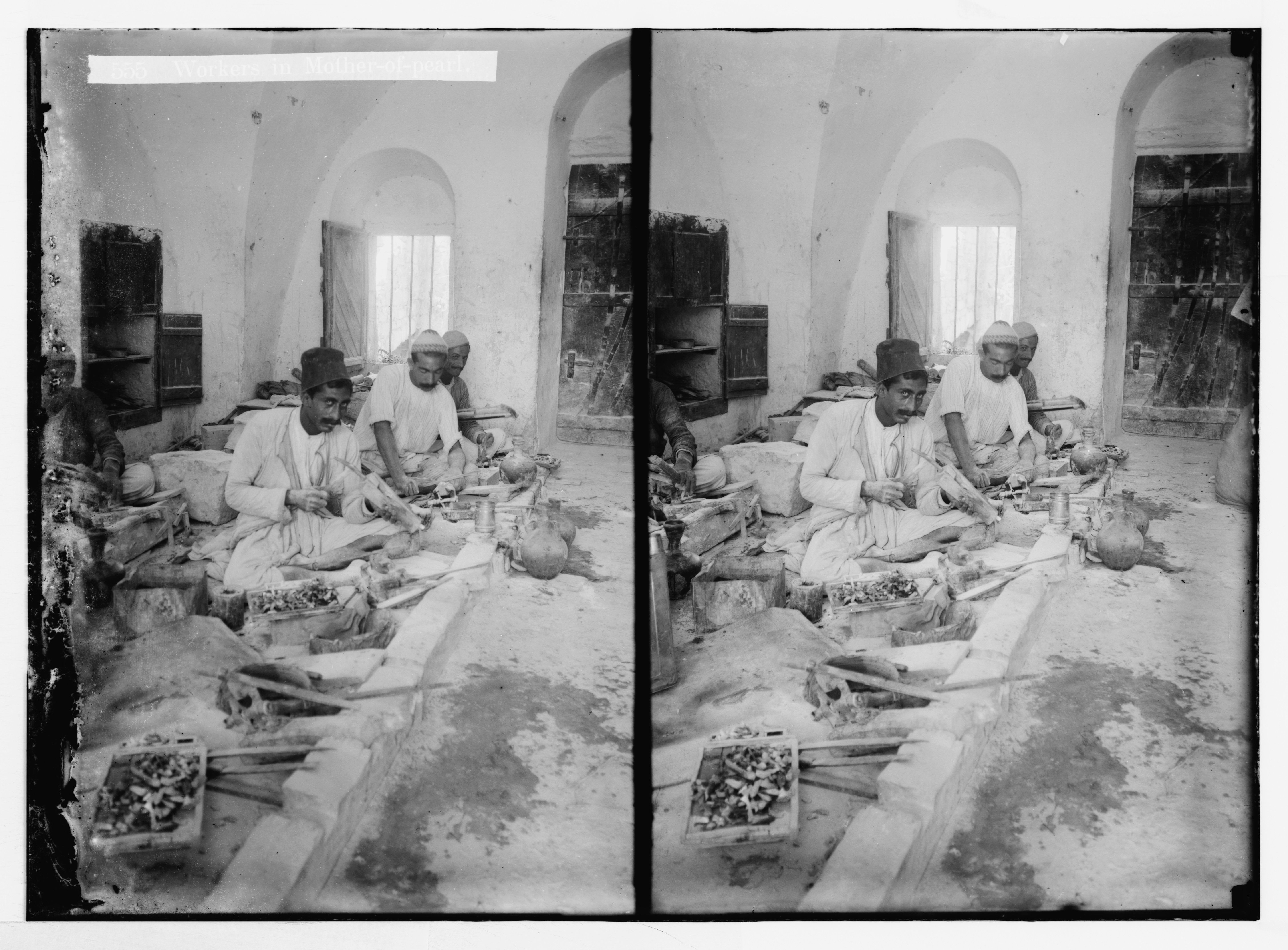 Stereoscopic photograph of a group of men seated around a long table in a room, enjoying a meal.