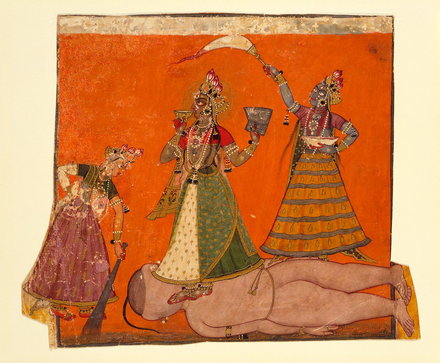 A vibrant and detailed painting depicting a scene from Hindu mythology. Three deities stand on a large, reclining figure, likely a demon or a defeated enemy. The deities are dark-skinned, adorned with elaborate jewelry, and wearing ornate clothing. The background is a solid, warm orange color.