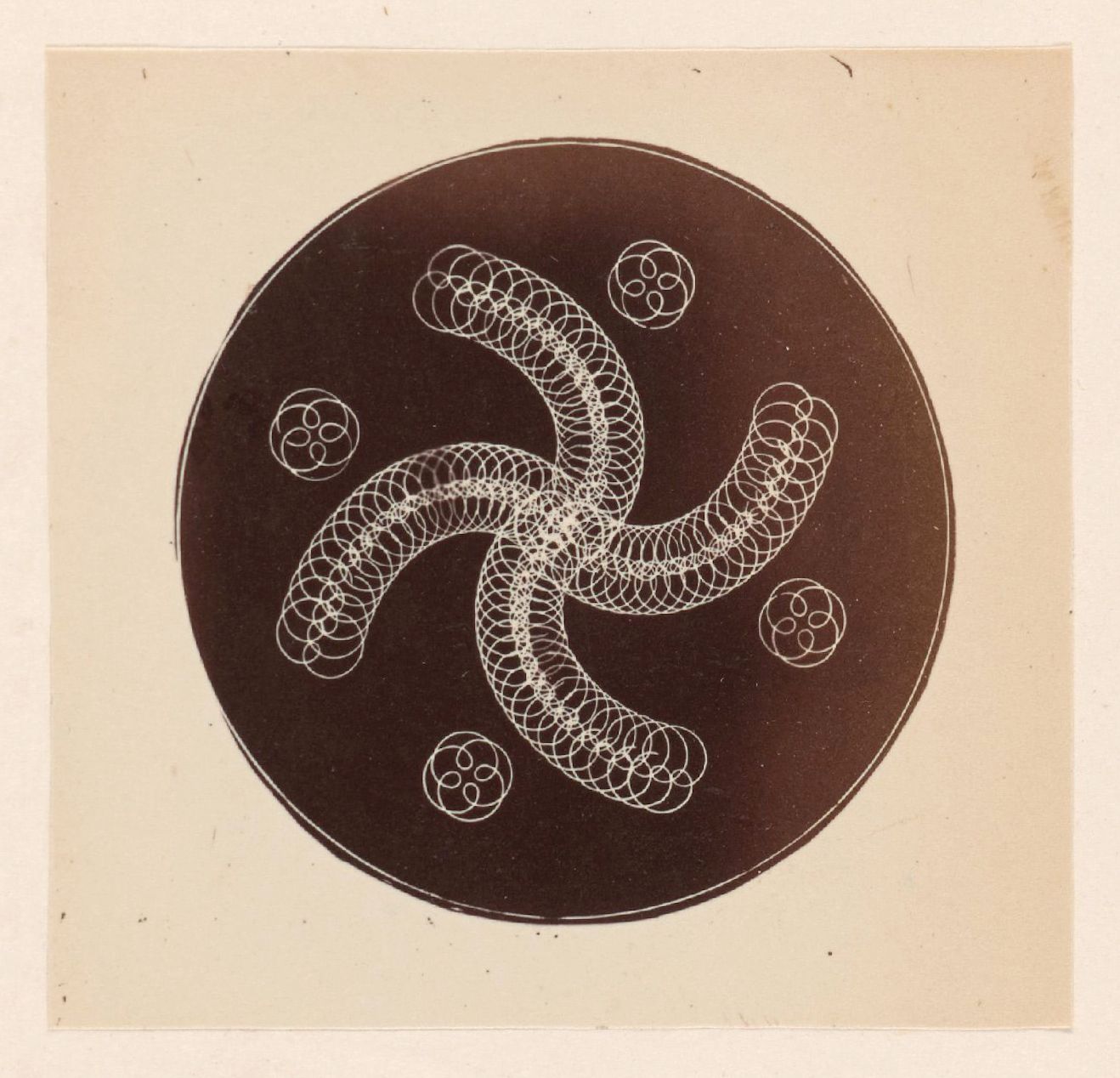 A circular design with a complex pattern of interconnected circles on aged paper.