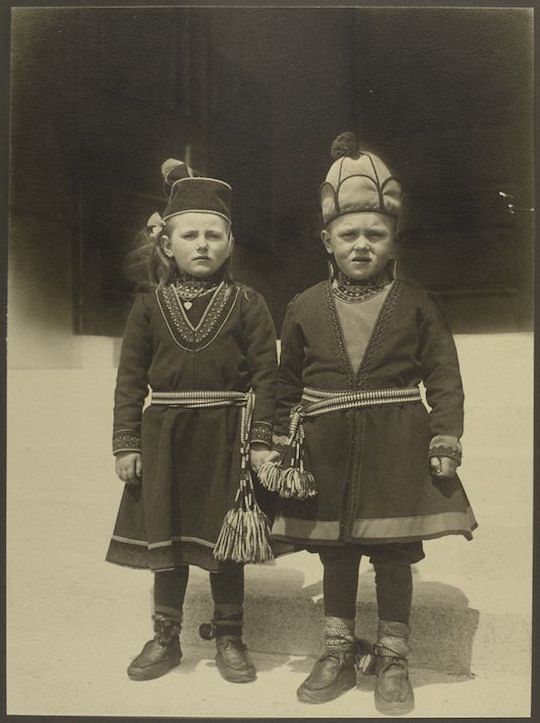 Black and white photograph of two young children in traditional Sami clothing.
