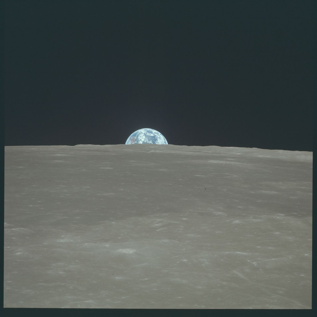 A view of Earth rising above the lunar horizon, taken from the surface of the Moon.