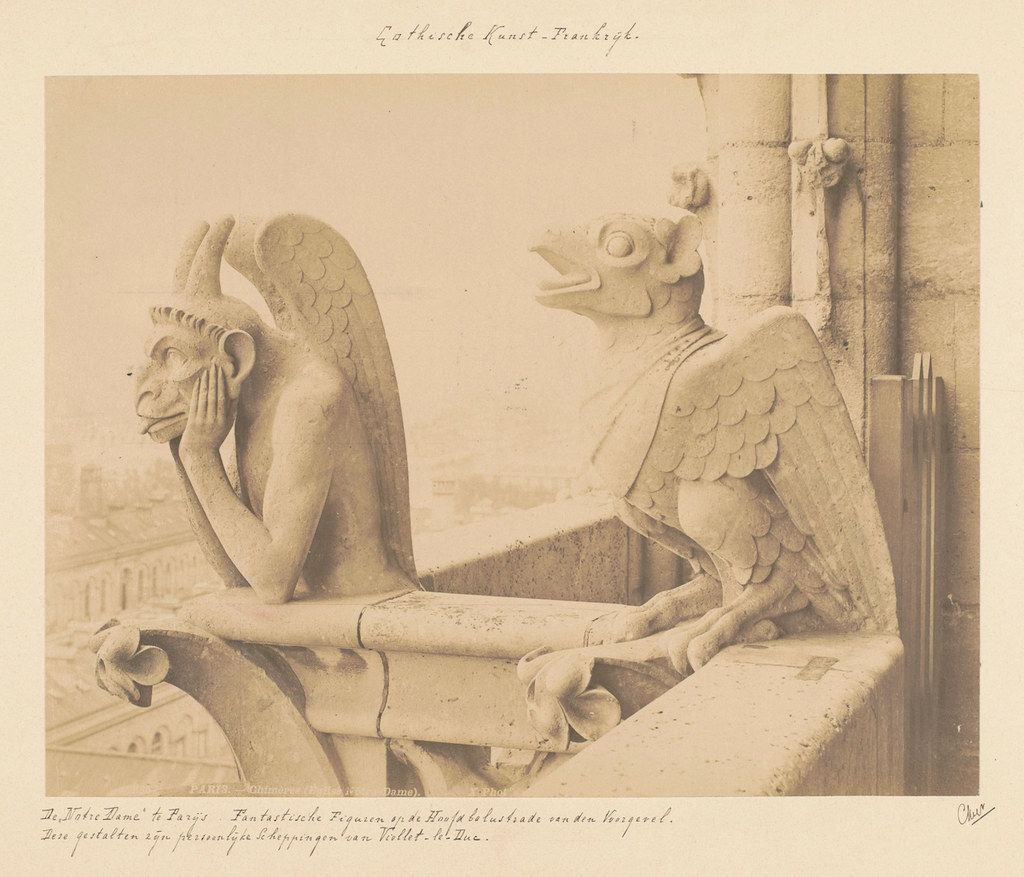 Sepia-toned photograph of a detailed stone sculpture, likely a gargoyle, adorning a Gothic building.