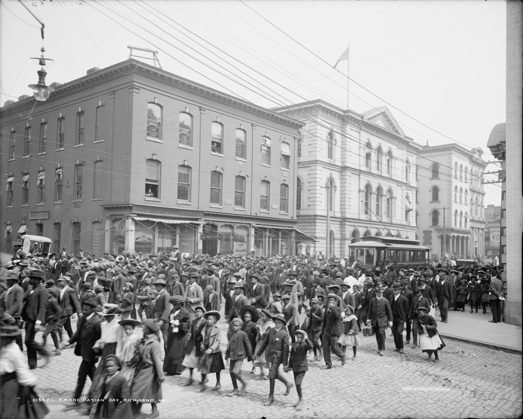 A black and white photograph of a large crowd of people filling a city street, likely commemorating Emancipation Day in Richmond, Virginia.